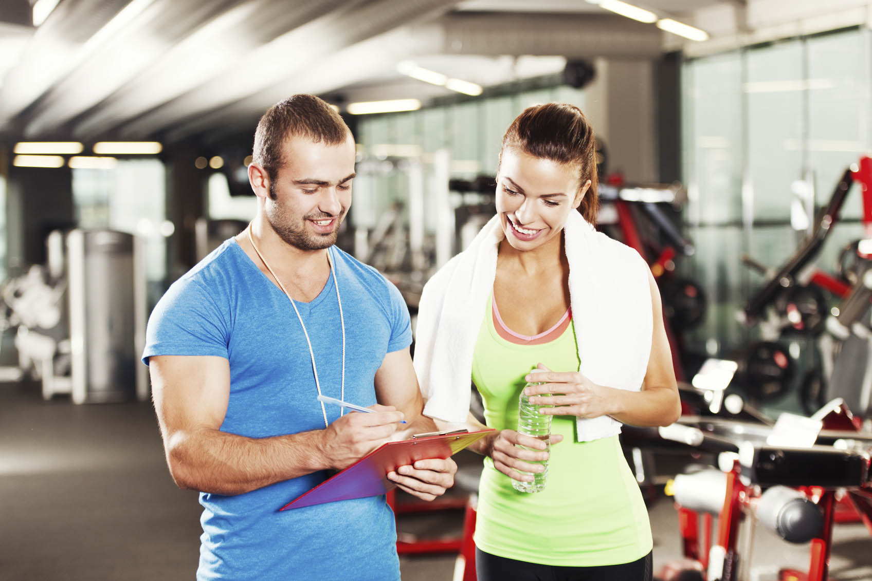 Woman in a gym with personal trainer Woman in a gym with personal trainer